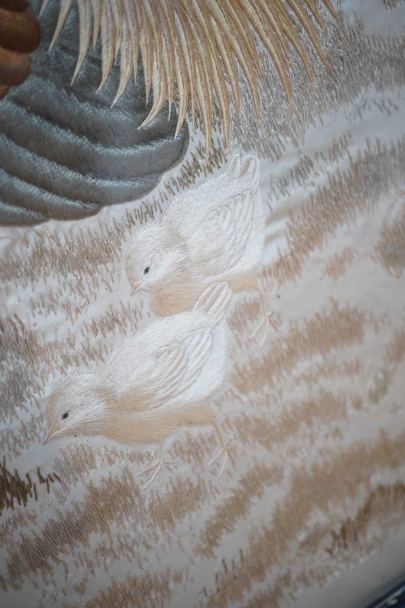 A Victorian fire screen inset with a Japanese cream silk embroidered panel of a cockerel, hen and two chicks, beautifully embroidered with rows of couched silk on the bodies of all the birds, their feathers and faces inc